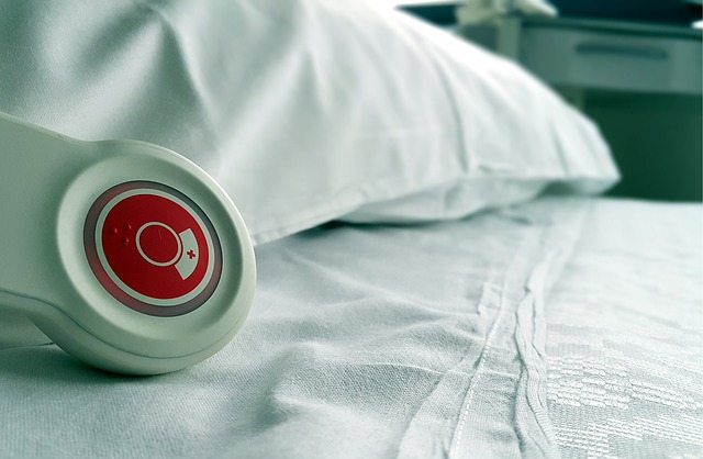 Hospital bed closeup with red call button